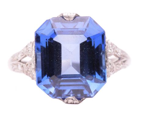 A synthetic sapphire and diamond ring, circa 1920s, containing an octagonal step-cut synthetic sapphire in raised claw mount 