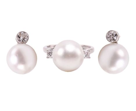 A pair of pearl and diamond earrings and a ring en suite; the central single freshwater pearl flanked by a single round brill