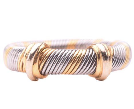 Cartier - a bi-coloured 'Aurore' ring, diagonally wrapped with alternating bands of yellow metal and steel, ornated with two 