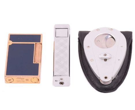 An S.T Dupont lighter with blue lacquer and gilt finish, a chrome lighter of a rectangular prism and a Xi3 folding cigar cut 