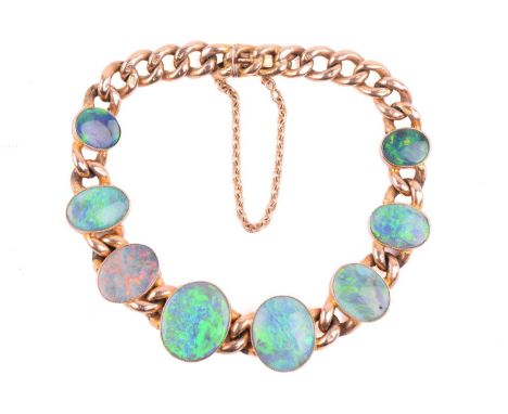 An opal bracelet in 9ct gold, comprising eight graduated oval black opal in millgrained collets, displaying vivid spectral pl