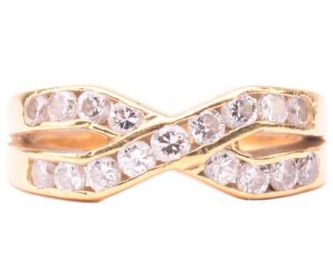 A diamond cross over ring, set with two rows of round brilliant cut diamonds in a channel setting, with a total estimated dia