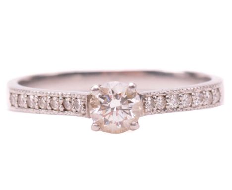 A single stone diamond ring, the round brilliant cut diamond in simple four claw mount, with diamond set shoulders in plain p