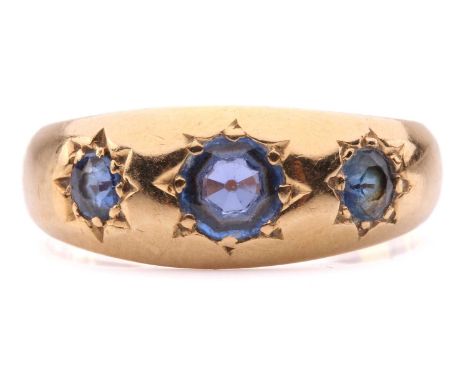 An Edwardian three-stone sapphire gypsy ring in 18ct gold, star-set with three graduated circular-cut sapphires to a tapered 