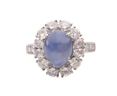 A star sapphire and diamond entourage ring, centred with a star sapphire of 9.7 x 7.7 x 6.0 mm, with greyish-blue body colour