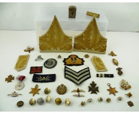 A QUANTITY OF PRESSED METAL AND EMBROIDERED FABRIC MILITARY BADGES AND INSIGNIA, also a TRENCH ART LIGHTER etc. 