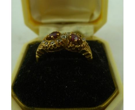 AN 18CT GOLD RUBY AND DIAMOND CROSSOVER RING having two mixed cut stones with an S entwined of cushion brilliants (one missin