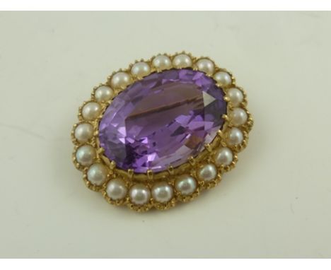 A 9CT GOLD SCARF BROOCH set with an oval amethyst and seed pearl around, London probably 1989 