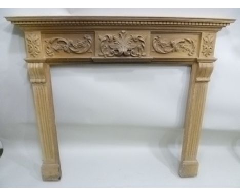 A 20TH CENTURY PINE ADAM DESIGN MANTELPIECE FIRE SURROUND the dentil cornice over acanthus leaf and floral carved frieze, wit