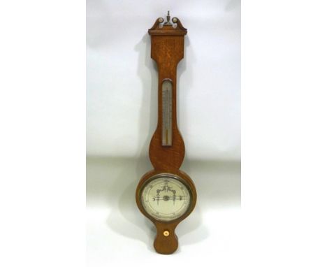 A 19TH CENTURY OAK CASED BAROMETER, having classical swan neck crest over thermometer with barometer below, silvered calibrat