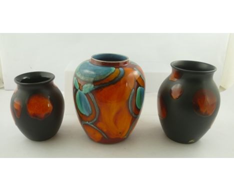 A DELPHIS POOLE POTTERY VASE of ginger jar form 21cm high, together with two OTHERS having black ground with red circle decor