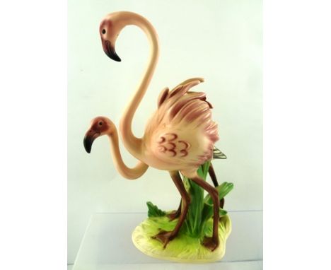 A GOEBEL MODEL GROUP OF A PAIR OF FLAMINGOS on reeds, set on an irregular oval base decorated in polychrome, with printed and
