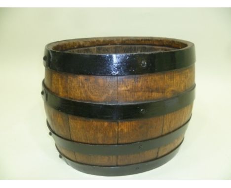 AN EARLY 20TH CENTURY OVAL COOPERED PLANTER with four metal bands, 24cm high x 30cm wide 