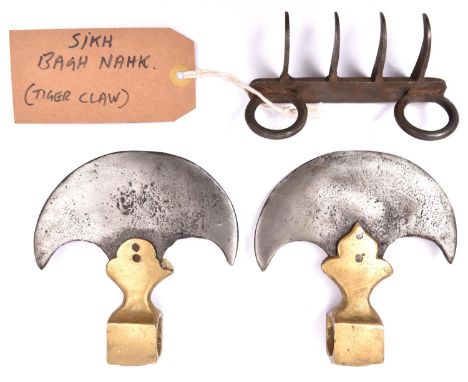 A reproduction Indian tiger claw weapon, Bagh Nakh; and a pair of Indian axe heads with crescent blades and brass sockets. Ba