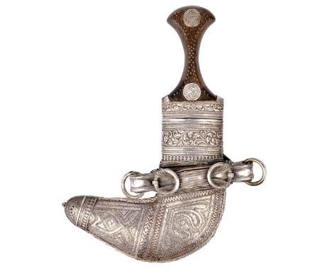 An Omani dagger (jambiya), curved blade 6 in., horn hilt set with coins, scabbard clad in embossed white metal and with chara