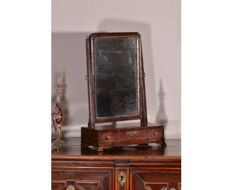 A George II mahogany dressing mirror, circa 1750, the rectangular swing plate supported by two tapering rectangular uprights,
