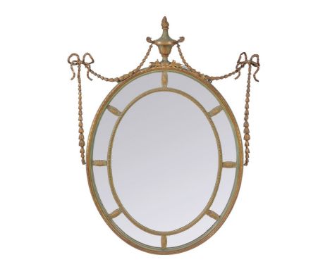 A painted and parcel gilt composition wall mirror in George III Adam style, late 19th century, with oval plate surrounded by 