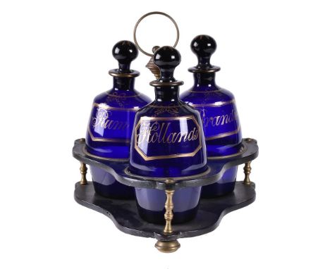 A Regency papier mâché tripartite decanter stand and three blue glass barrel-shaped decanters and stoppers, first quarter 19t