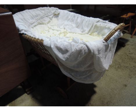A vintage wicker dolls crib on wooden wheeled frame