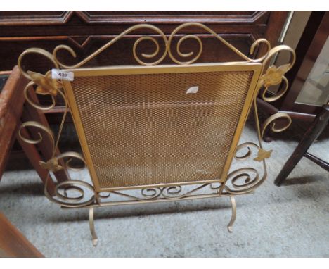 A vintage brassed fire screen