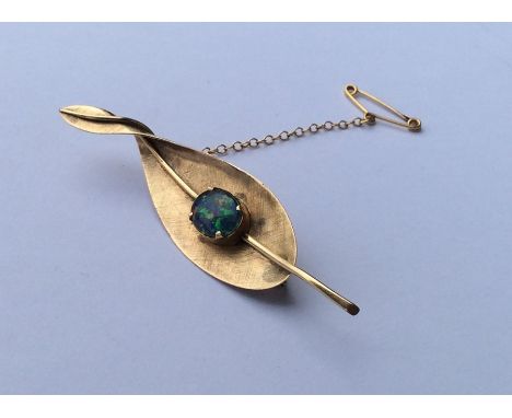 An unusual 14 carat gold opal mounted brooch in the form of a eucalyptus leaf. Approx. 6 grams. Est. £100 - £150.