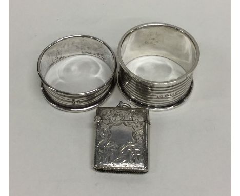 A heavy silver engraved vesta case together with two engine turned napkin rings. Various dates and makers. Approx. 34 grams. 