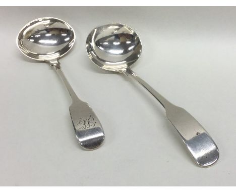 EXETER: A silver fiddle pattern cream ladle together with one other. Approx. 44 grams. Est. £30 - £40.