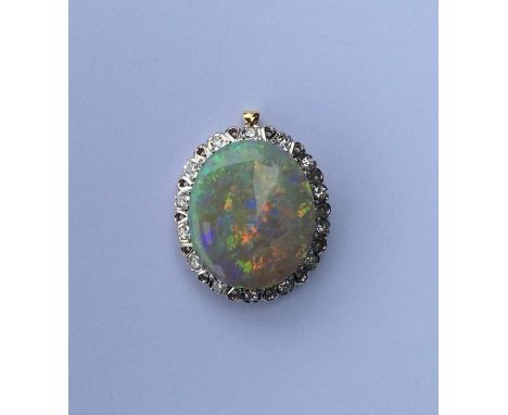 A good opal and diamond large pendant with brilliant cut diamond border to two colour gold frame. Approx. 14 grams. Est. £400