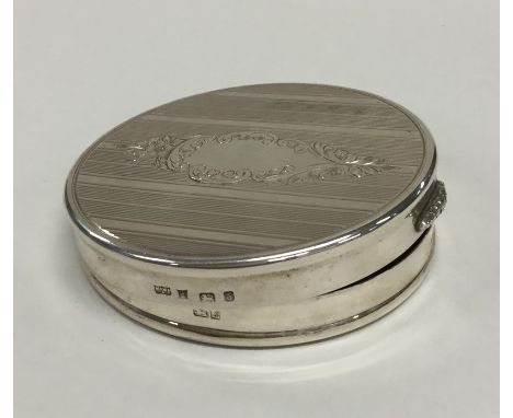 A modern circular silver hinged top compact with vacant cartouche. Birmingham. Approx. 75 grams. Est. £40 - £60.