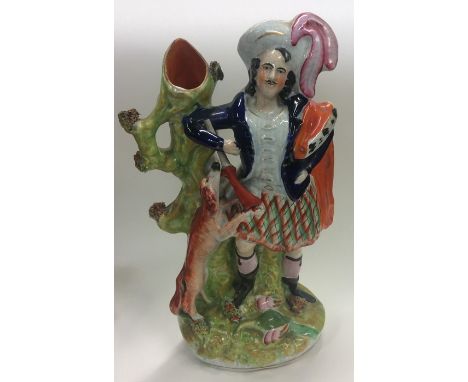 A Staffordshire spill vase, highly coloured and finely modelled as a huntsman wearing a plumed hat and iron red cloak holding