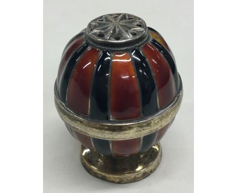 An unusual silver and enamel pepper with gilt interior. Approx. 16 grams. Est. £45 - £55.
