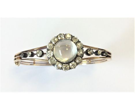 A good quality Victorian moonstone and diamond hinged bangle in the form of a cluster with tapering diamond shoulders and con