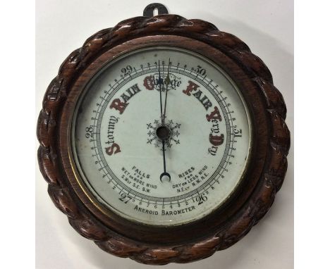A carved oak aneroid barometer. Est. £20 - £30.
