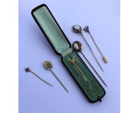 A quantity of gold and other stick pins to include a hunting example. Est. £30 - £40.