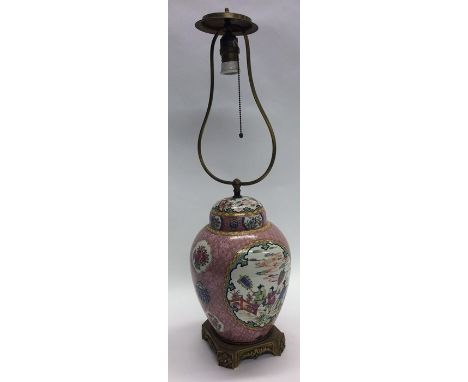A pink ground Chinese vase and cover mounted as a lamp in bright colours. Approx. 70 cms high. Est. £40 - £60.