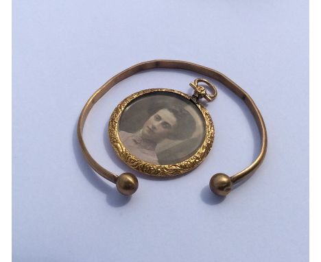A small gold torque bangle together with a gold locket. Approx. 15 grams. Est. £50 - £80.