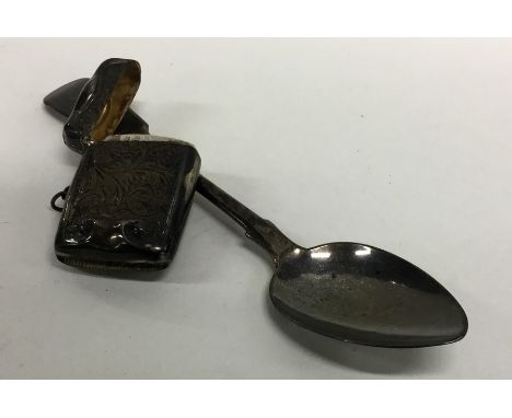 A small engine turned silver vesta case together with a tablespoon. Approx. 20 grams. Est. £20 - £30.