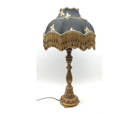 A composite gilt effect table lamp, with black shade embroidered with butterflies and finished with beaded tassels, overall H