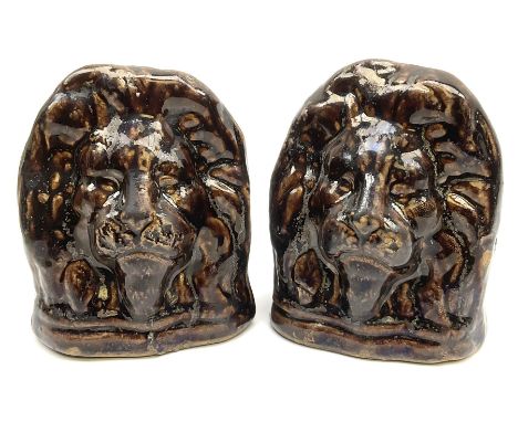 A pair of treacle glaze sash window rests, possibly Rockingham, modelled in the form of lion heads, each approximately H12.5c