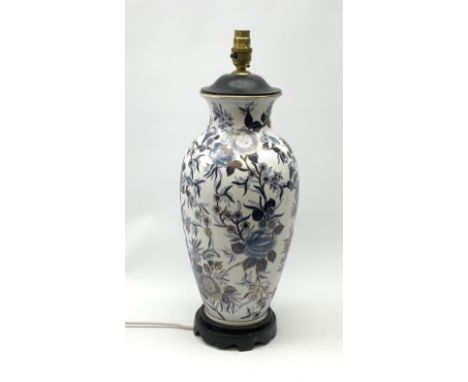 An Oriental style table lamp, of baluster form decorated with blue flowers upon a white ground and heightened with gilt, with