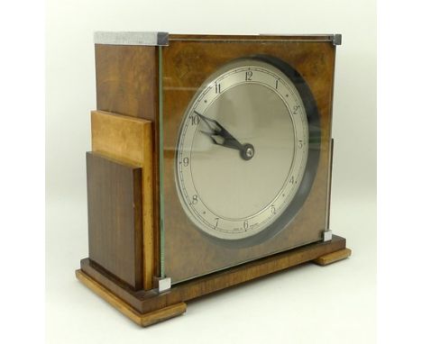 An Empire, Art Deco walnut cased mantle clock of stepped, square form with a glass front and chrome mounts, silvered dial bea