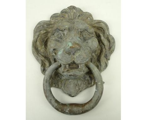 A brass door knocker in the form of a lion's head, 30 by 20cm.