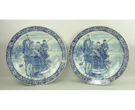 A pair of Boch Royal Sphinx Delft chargers, decorated with a horse and sled, 38cm diameter. 