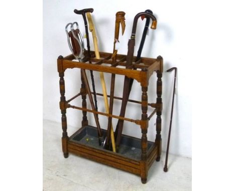 An oak umbrella stand, circa 1930's, with ten divisions and galvanized drip tray, 54 by 25 by 66cm high, together with a Fult