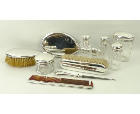 A silver dressing table set comprising hair brush, clothes brush, hand mirror, comb, a button hook with silver handle, and fi