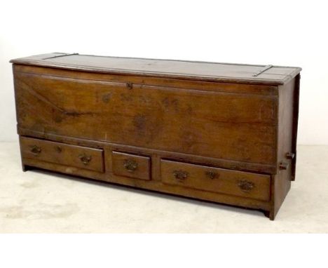 A 17th century oak mule chest, with a hinged planked top above a front panel with punchwork initials and date; M.M. 1611, abo