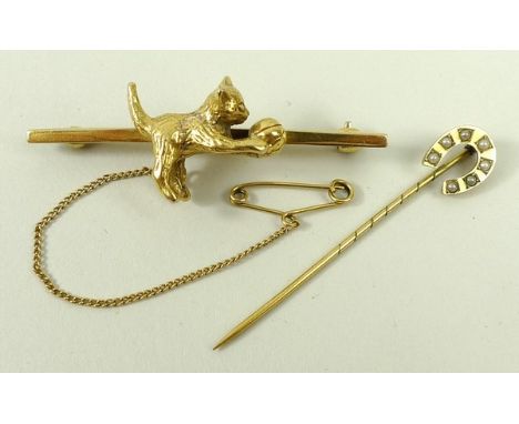 A 9ct gold bar brooch modelled with a kitten playing with a ball, with a safety chain as fitted, and a 9ct gold horseshoe sti