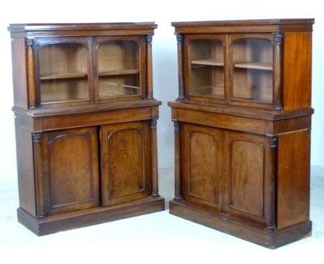 A pair of 19th century mahogany bookcases, with an outswept cornice over two glazed doors enclosing an adjustable shelf, flan