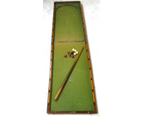 A Victorian mahogany cased bagatelle, with balls and cues, size folded, 45 by 92 by 12cm.