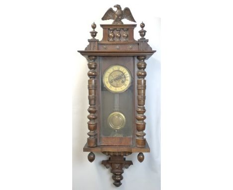 An oak cased Vienna wall clock, early 20th century, brass dial with enamel chapter ring bearing Roman numerals, eight day mov